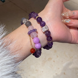Close-up of elegant purple amethyst beads and colorful crystal bracelets on a wrist