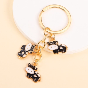 Cute cartoon cow keychain in gold alloy with black and white enamel charm
