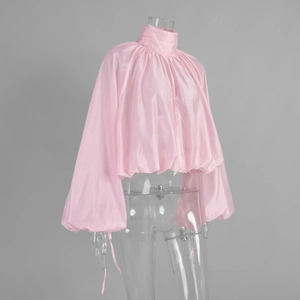 Detail of pink high neck blouse with lantern sleeves and metallic sheen texture