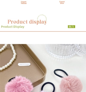 Detail of plush pink pom pom hair ties with elastic bands on a gold tray