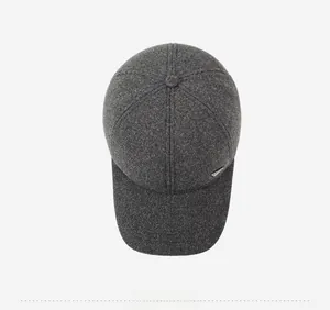 Top view of a dark grey woolen baseball cap showing seam details and metal logo