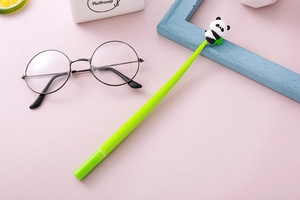 Close-up of green panda gel pen featuring a cute 3D panda topper on a pink desk setup