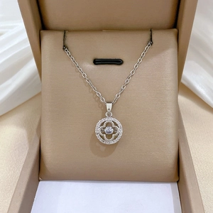 Macro shot of silver four-leaf clover necklace with sparkling zircon pendant in jewelry box