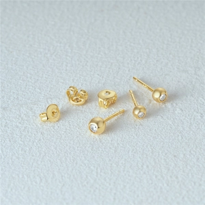 Detailed macro view of S925 silver gold plated stud earrings with white cubic zirconia sets