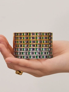 Macro detail of stacked stainless steel bracelets with multicolored rectangular zircon stones