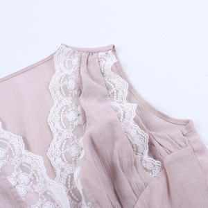 Detail of light pink sleeveless top featuring delicate white lace trim on the neckline