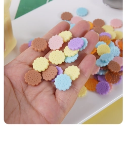 Detailopname van mini hars koekjes bedeltjes voor DIY ambachten op een vingertop