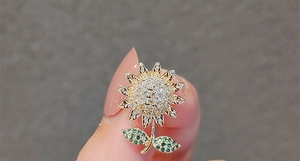 Vue détaillée d'une broche tournesol en métal doré avec des pétales en zircon blanc