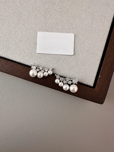 Detailed macro view of S925 silver stud earrings with gradient pearls and zircons