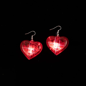 Close-up of LED glowing heart earrings with romantic red light for Valentine's Day