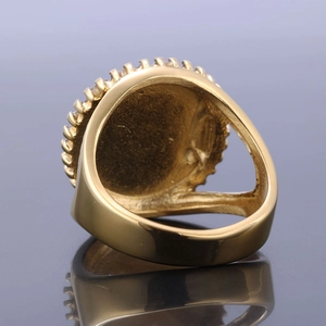 Macro shot of gold-plated signet ring showing pavé zircon edge and polished inner band