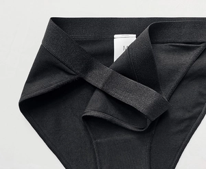 Close-up of the size M label and knit cotton texture on black breathable panties