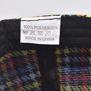 Detailed interior of plaid baseball cap showing 100% polyester lining and wash care label