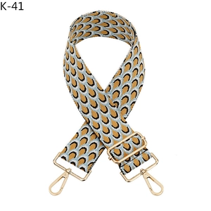 Détail de la bandoulière tissée motif paon avec mousquetons métalliques dorés