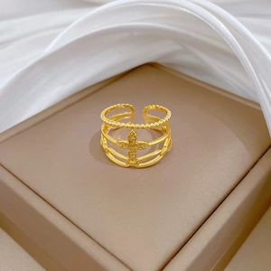 Close-up of golden adjustable four-leaf clover ring with beaded edges on a jewelry stand