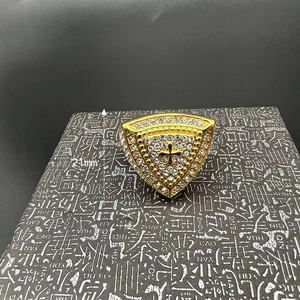Detail of hip hop gold-plated men's ring with rhinestone triangle and cross motif