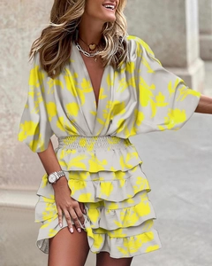 Detail of V-neck white floral dress with layered ruffle hem and elastic waist