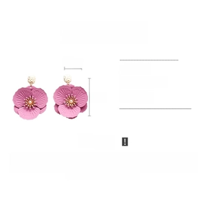 Detail view showing pink flower earrings with imitation pearls and gold hammer texture