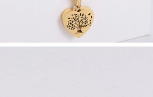 Macro detail of golden heart pendant featuring intricate Tree of Life cutout design