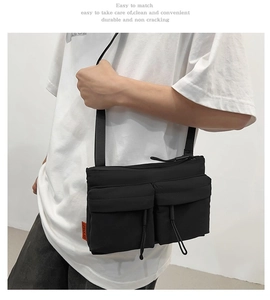 Detail of durable nylon messenger bag with double front pockets and adjustable strap