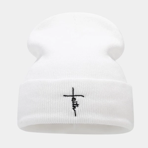 Detailed view of faith cross embroidery on white ribbed knit beanie for winter