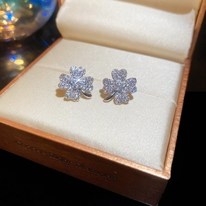 Detailed macro of sparkling zircon clover earrings presented in a luxury jewelry gift box
