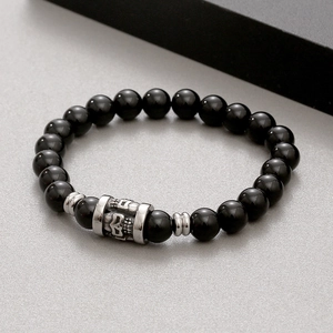 Tiger eye agate beads bracelet with vintage titanium steel skull charm on grey stone surface