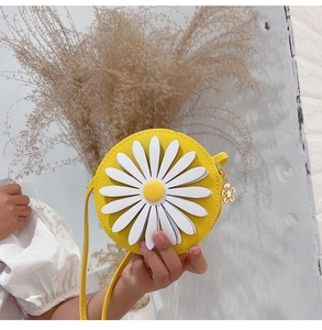 Macro view of a round yellow kids crossbody bag featuring a 3D daisy and gold flower zipper