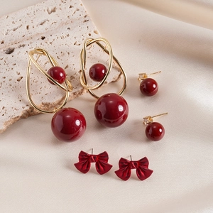 Three pairs of vintage red and gold earrings with large beads and bowknot designs