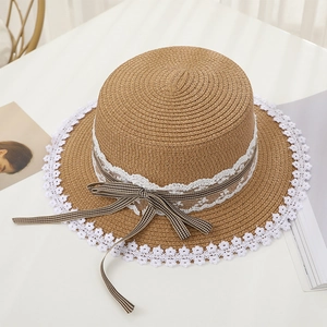 Detailed top view of a straw sun hat featuring white floral lace and a plaid ribbon bow