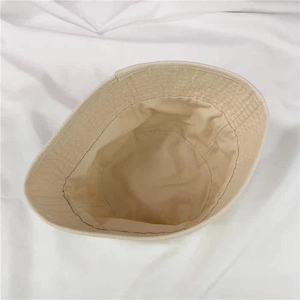 Detailed interior view of a beige canvas bucket hat showing quality stitching