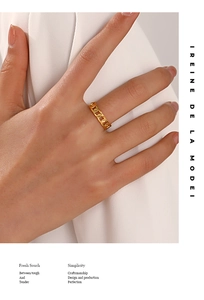 Macro detail of golden chain link ring design with polished texture and hollow pattern