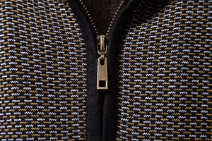 Détail macro du pull en maille pour hommes avec fermeture éclair en bronze vintage premium