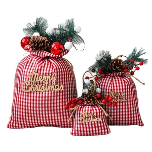 Set of three red and white plaid Christmas drawstring gift bags with pine cone accents