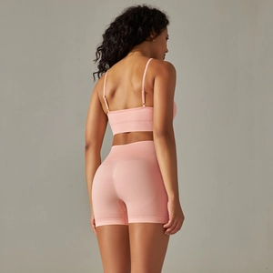 Detail view of the seamless pink sports bra and high-waist shorts on a fitness model