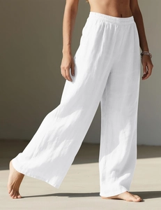 Close-up of white linen wide-leg trousers showing elastic high waist and fabric texture