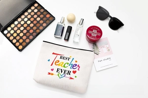 Flat lay of teacher gift cosmetic bag with Best Teacher Ever print and makeup accessories