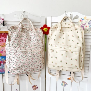 Detail of floral canvas backpacks hanging in a soft, bright aesthetic setting