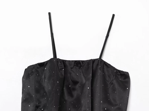 Détail du haut en satin noir orné de strass argentés scintillants pour femme