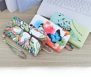 Detailed view of long zip-around wallets with vibrant floral and life tree patterns on wood
