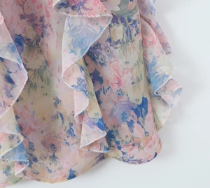 Detail showing layers of floral ruffles and lightweight chiffon fabric on the dress