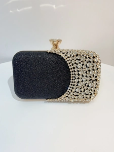 Detail of elegant black glitter evening clutch with crystal mesh and gold diamond clasp