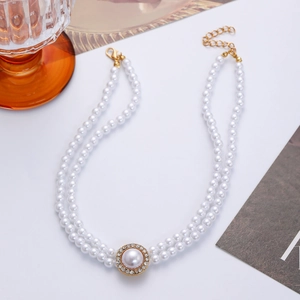 Détail du collier de perles à double rangée avec pendentif strass et fermoir doré