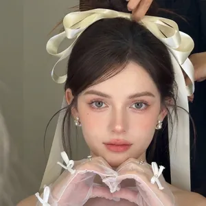 Elegant white satin oversized bow hair clip with matching lace mesh gloves for bridal look
