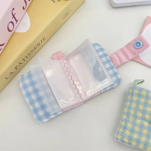 Detailed view of mini checkered photo album with pink snap closure and clear plastic inserts