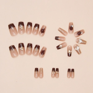 Macro view of burgundy ballet nails with crystal hearts and gold glitter accents