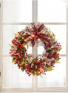 Close-up of a 50cm Christmas wreath with red berries and warm LED lights on a window