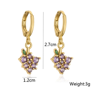 Detail view of gold hoop earrings with grape-shaped purple and green zircon pendants