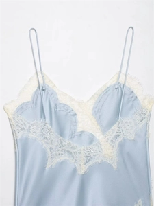 Detail of light blue satin lingerie top with white lace neckline and thin straps