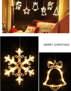 Macro detail of snowflake and bell LED window lights with warm holiday glow
